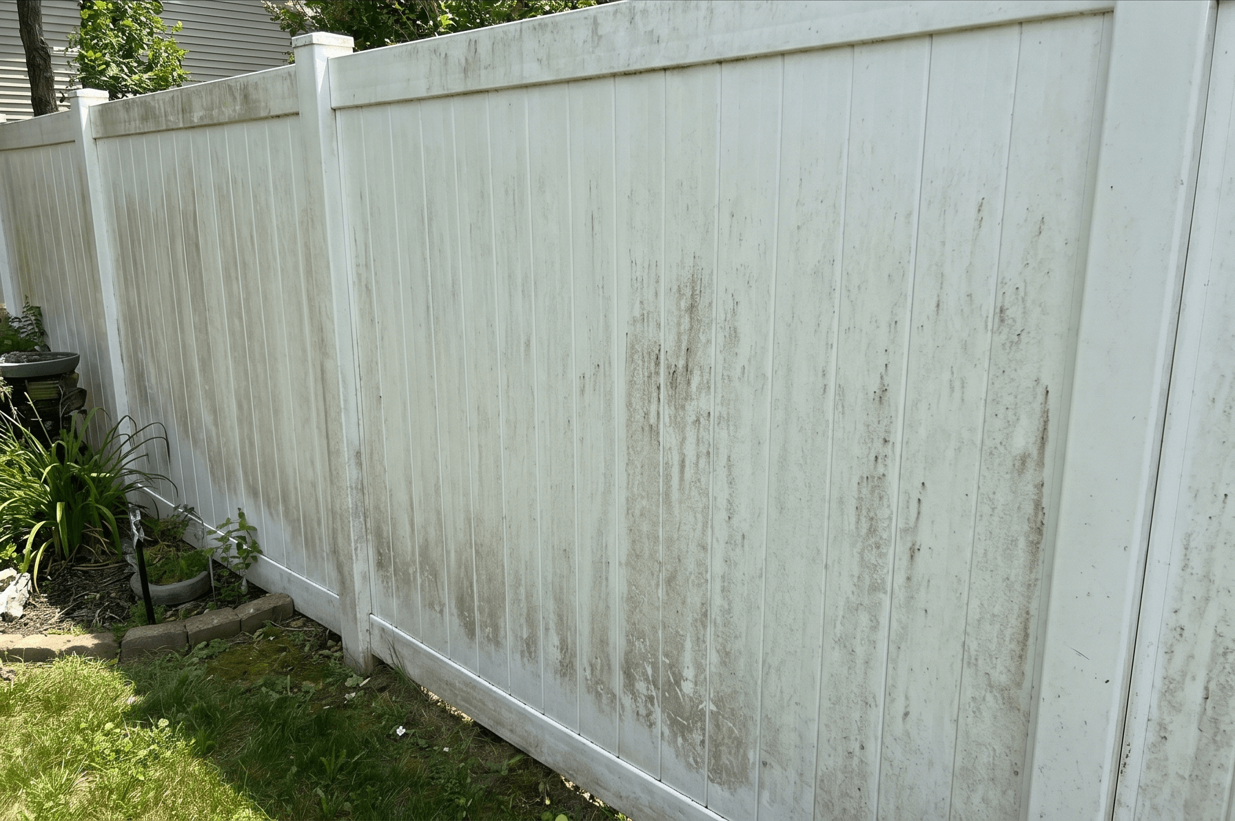 Dirty white vinyl fence with algae and mildew before cleaning in Elmhurst, IL